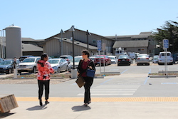 two women going in opposite directions in front of the building